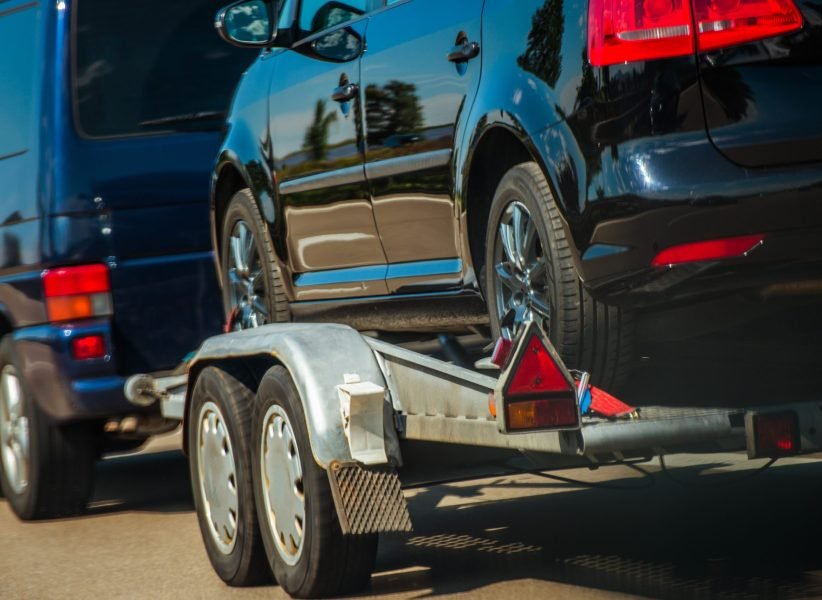 Used Cars Importing in European Union. Van Pulling Trailer with Damaged Pre Owned Vehicle For  Sale in Other Country.