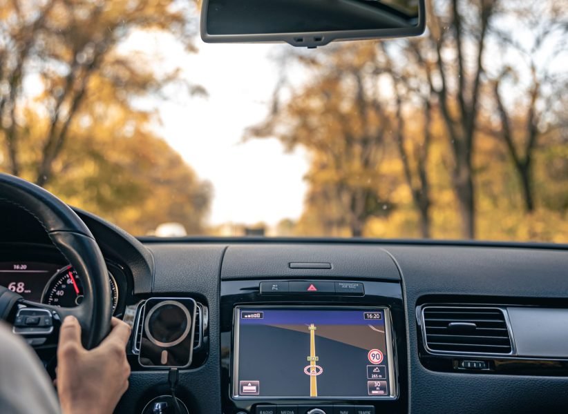 Attractive young woman driving a car, inside view, traveling in a private car.
