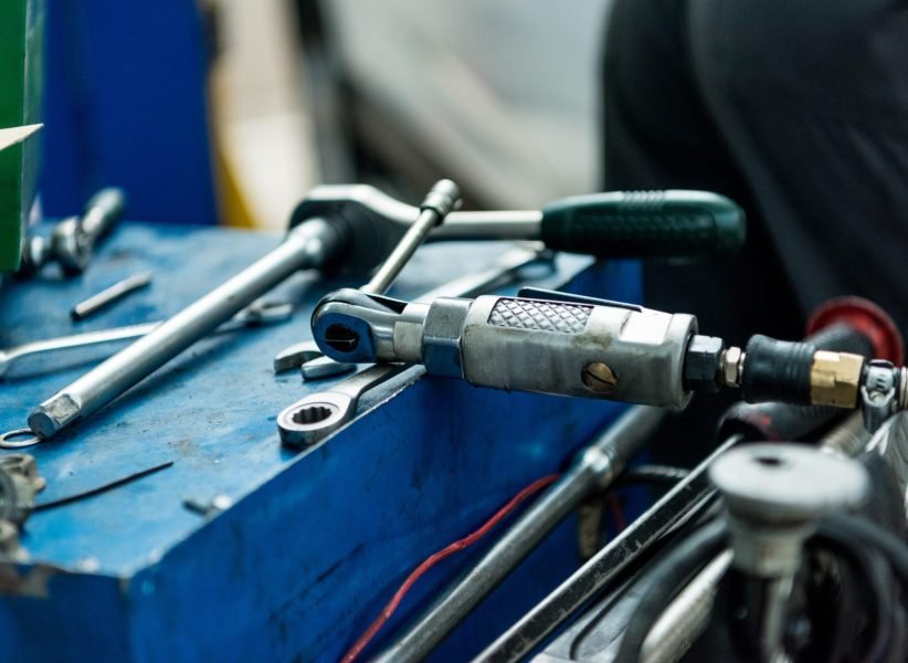 Close up of auto repair tools layed out on a table in a car service workshop.